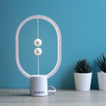 Lampa amplasată pe birou, iluminând discret spațiul.